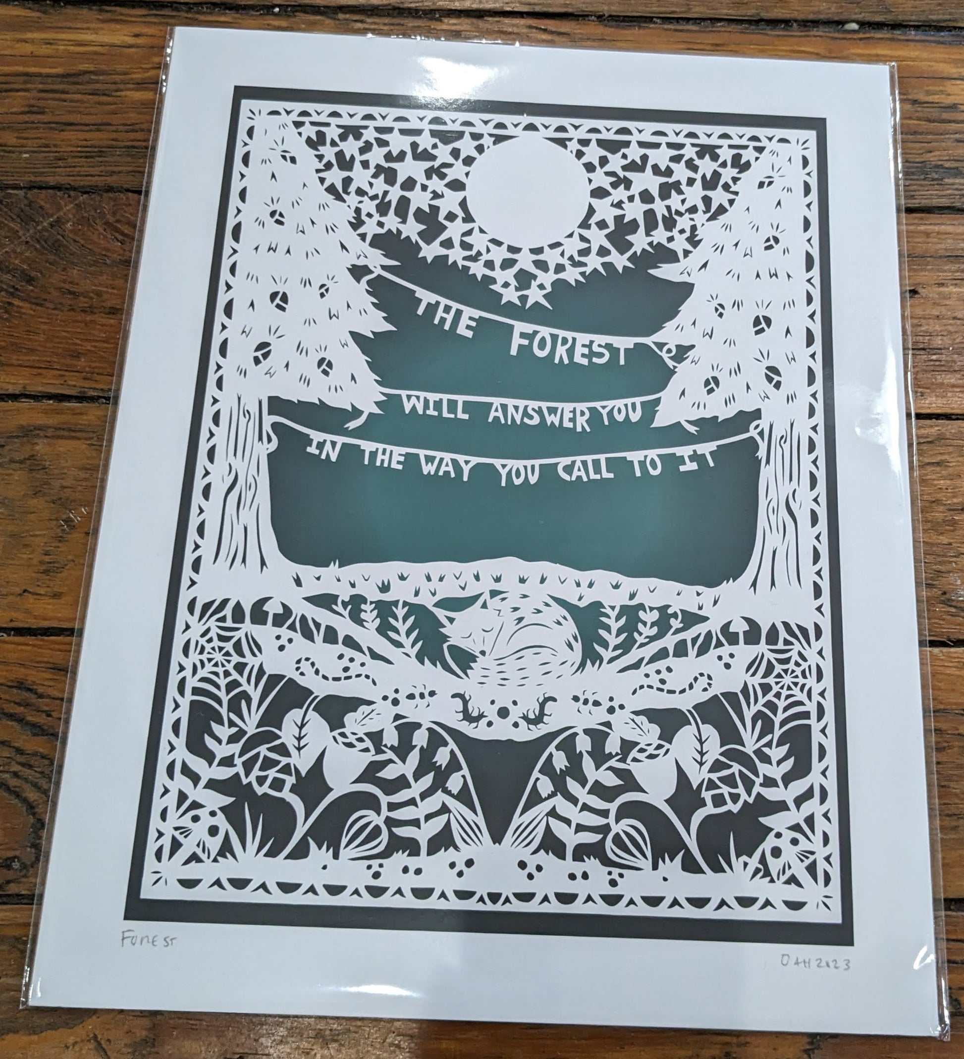 White papercut on gradient teal background featuring the Finnish proverb ” The forest will answer you in the way you call to it”