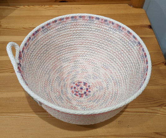 White rope basket with purple and pink threading and a cute loop handle
