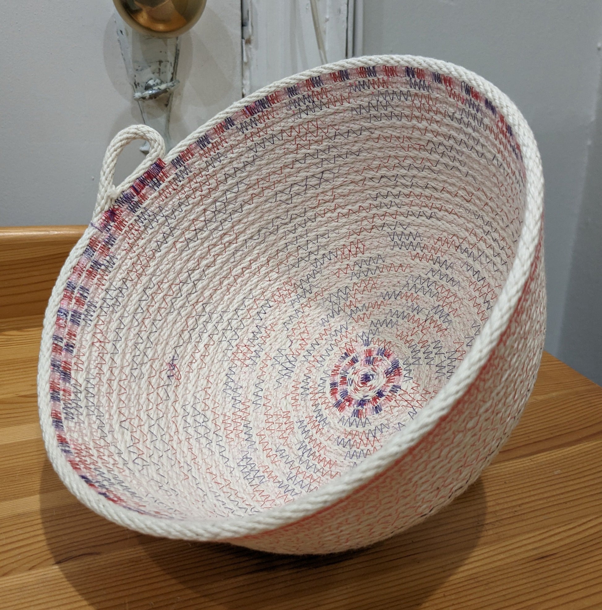 White rope basket with purple and pink threading and a cute loop handle