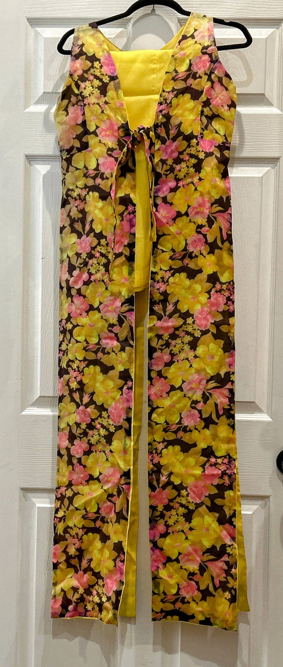 Long, sleeveless, paneled tunic (tie closure) with pink and yellow floral design on brown background and silky yellow pants to match.