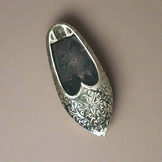 brass gold-colored ashtray shaped like an Indian slipper with ornately carved patterns