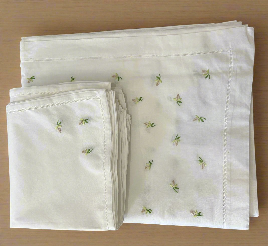 white cotton tablecloth and napkins with embroidered flower buds and eyelet edging