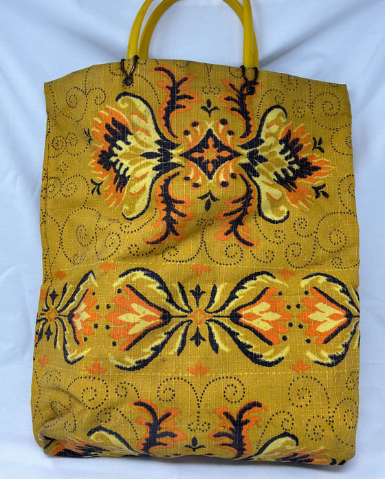 Vintage fabric tote with plastic handles, mustard yellow with black, orange, and chartreuse patterning