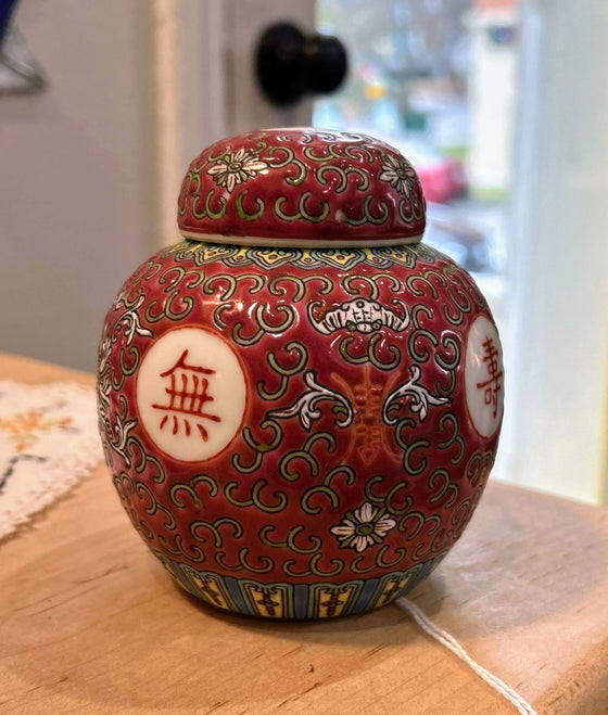 Red ceramic Chinese tea/spice vessel decorated with white circles and Chinese characters