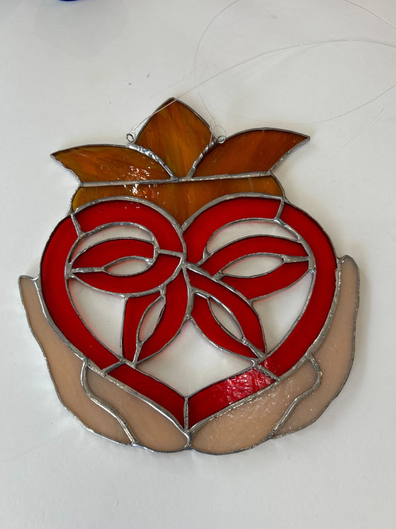 Claddagh heart made with red, beige, and orange hues of stained glass