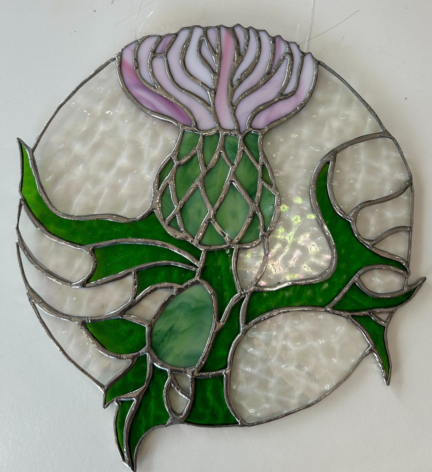 Stained glass pink thistle with texture glass circle, made with pink, green, and transparent hues