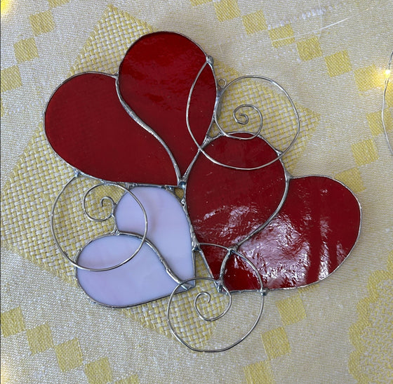 Trio of stained glass hearts - two red, one white - gathered with whimsical wire swirls
