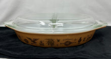  Divided covered baking dish, 1.5 quart capacity. Clear glass top, Caramel colored base with Early American stencil patterning