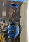 Translucent blue glass lantern with metal accents and hook