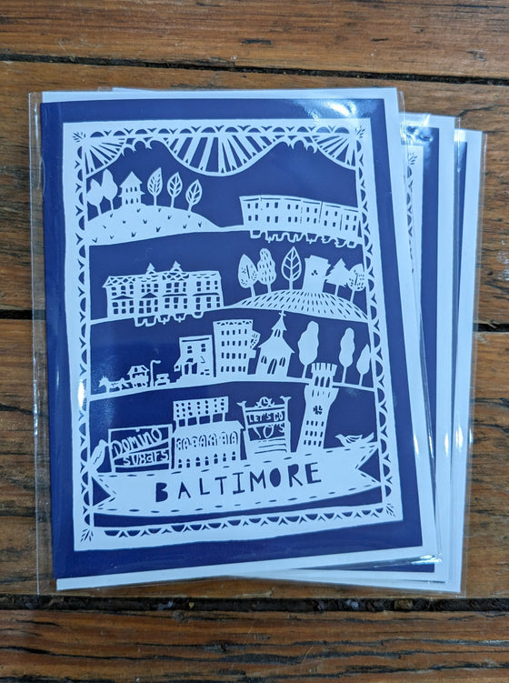 Baltimore cityscape white paper-cut on blue background
