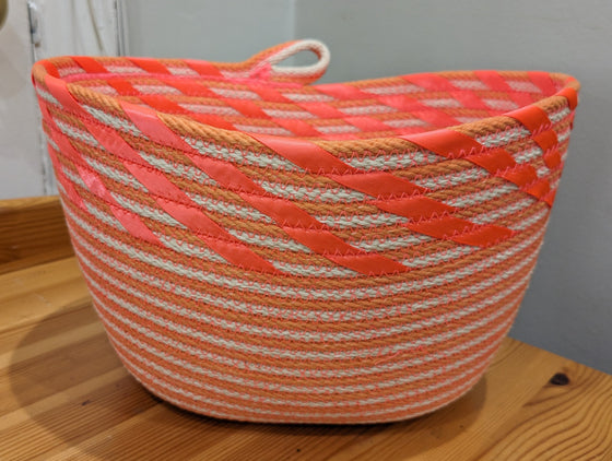Orange and white striped rope basket with coral ribbon edging and a cute loop handle