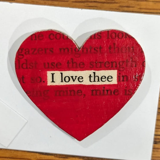 Red heart-shaped pin with text transfer highlighting "I love thee"