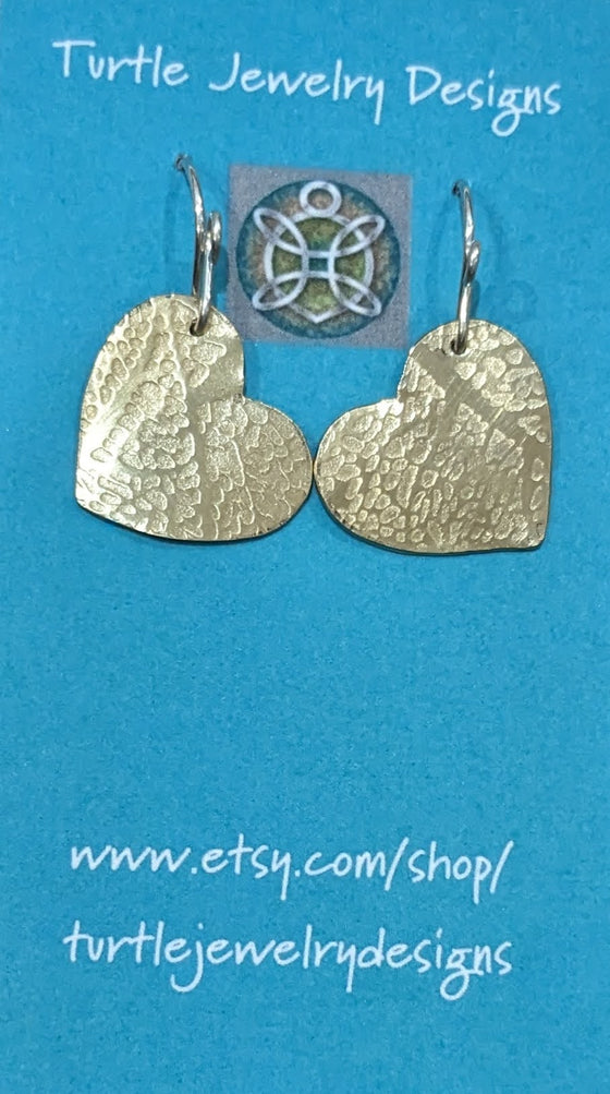 Dangle earrings featuring leaf imprints on brass hearts