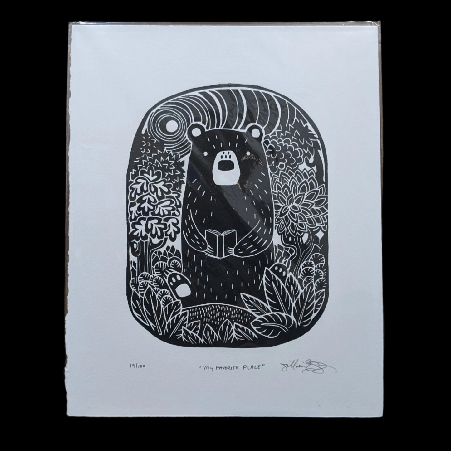 bear holding a book surrounded by the jungle, encased in a bubble